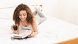© Prostock-studio - Young girl reading book in bed with coffee