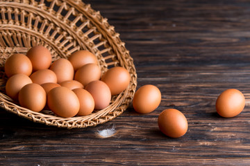 Wall Mural - chicken eggs in a straw tray on an old wooden table