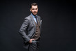 © opolja - A confident elegant handsome young man standing in front of a black background in a studio wearing a nice suit.
