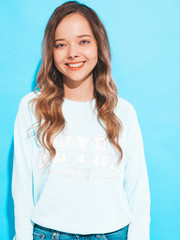 Portrait of of happy smiling girl with in casual clothes without makeup. Young woman model posing on blue background