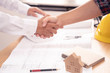 © somchaikhun - architect or civil engineer  and client or customer shaking hands for agreement of home or building plan,plan is fake only for stock photo.