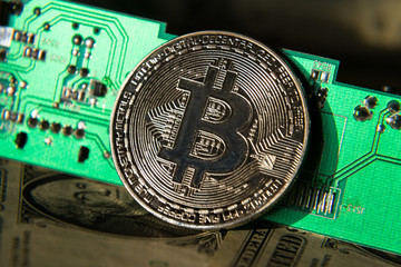Wall Mural - silver bitcoin coin with dollars and computer motherboard, cryptocurrency mining and investing conce