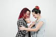 © spaskov - Two young women with a baby on a white background. Same-sex marriage and adoption, homosexual lesbian couple.