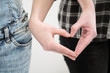 © spaskov - Two girls in jeans hold hands close up. White background. Homosexual lesbian couple.