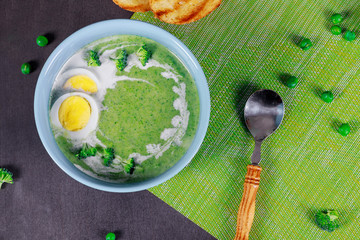 Broccoli cream soup and cooked chicken eggs on a table. Classic European food.