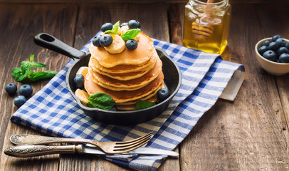 Wall Mural - Homemade pancakes in iron skillet on wooden background