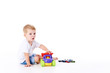 © oes - Cute boy plaing with toy car on floor, isolated on white
