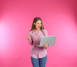 © New Africa - Emotional young woman with laptop celebrating victory on color background