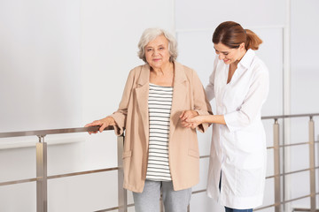 Canvas Print - Elderly woman with caregiver indoors. Space for text