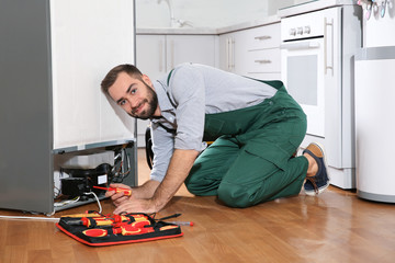 Sticker - Male technician in uniform repairing refrigerator indoors