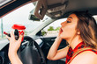Young recklessly woman in car doing make up