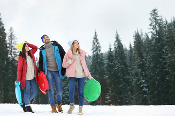 Canvas Print - People with plastic sleds outdoors. Winter vacation