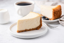 Cheesecake New York With Cup Of Coffee On White Table. Closeup View. Coffee Break With Slice Of Cake And Black Coffee