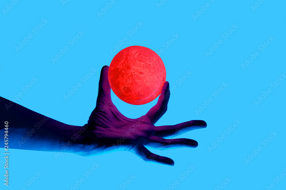 Isolated on blue background photo of man holding moon shape illuminated sphere. Surrealistic collage style, contemporary art element for design, posters and banners. Neon purple light. Pop inspiration - obrazy, fototapety, plakaty 