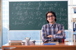 Young funny math teacher in front of chalkboard 