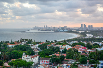 Aerial view of the historic city of Olinda in Pernambuco, Brazil at sunset contrasting with the contemporary skyscrapers of Recife in the far background