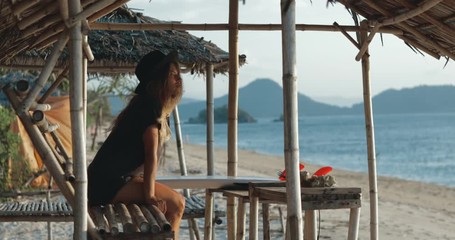 Wall Mural - Lonely woman traveler sitting and relaxing near sea