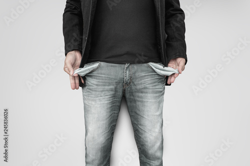 Fotomural Man showing his empty pockets on gray wall background.