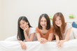 © kwanchaichaiudom - portrait of three pretty girls smile on bed