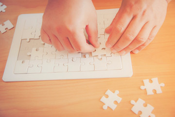 Closeup hand of man connecting jigsaw puzzle with sunlight effect, Business solutions, success and strategy concept