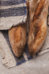 Two artisanal bread baguettes on linen towel. Traditional french baguettes made from wheat flour, top view.