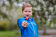 © Alyona - a large round red round Lollipop in the hands of a child in the foreground. spring