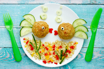 Wall Mural - Food art idea healthy lunch for kids chicken meatballs with bulgur porridge and fresh vegetables shaped cute fishes