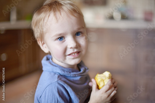 Cute Caucasian Little Boy With Blue Eyes And Blonde Hair Eats