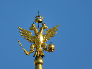 Wall Mural - Double-headed eagle, symbol of Russia isolated on blue sky background. Golden russian emblem on the top of tower on Red square in Moscow