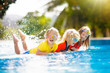 © famveldman - Kids in swimming pool. Children swim. Family fun.