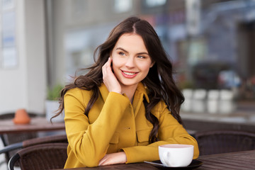 Sticker - drinks and people concept - happy young woman or teenage girl with cup of hot chocolate at city street cafe terrace