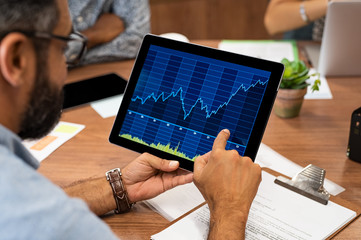 Business man reading stock market graph