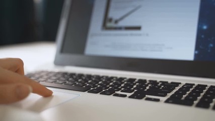 Woman fingers scrolling website using track pad for shopping online from home with daylight.