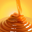 Flowing stream of golden caramel on a yellow background. High detailed realistic illustration.
