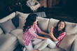 Close up top above high angle view photo cheerful mum little daughter scream shout yell overjoyed tickle leisure rejoice wear pink plaid shirts bright flat apartment room sit lying on cozy sofa divan