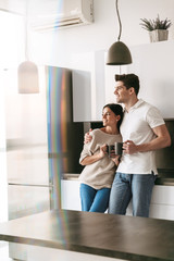 Wall Mural - Happy lovely young couple holding cups