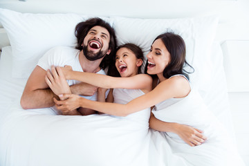 Wall Mural - Top above high angle view of nice cute sweet lovely adorable attractive cheerful cheery glad people lying in bed enjoying cuddling daddy in modern white light interior room indoors