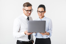 Business Colleagues Couple Isolated Over White Wall Background Using Laptop Computer.
