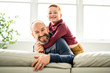 © Louis-Photo - Father with redhead child sit on the sofa at home