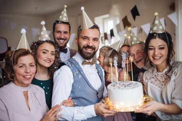 Wall Mural - A portrait of multigeneration family with a cake on a indoor birthday party.