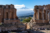 Fototapeta  - Volcano Etna seen through ruins of ancient Greek amphitheater in Taormina in Sicily