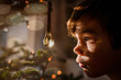 © RooM The Agency - Close-up side view of a Boy looking at a crystal ornament hanging on a Christmas tree