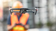 © zephyr_p - Asian engineer man or male worker flying drone over construction site. Using unmanned aerial vehicle (UAV) for land and building site survey in civil engineering project.
