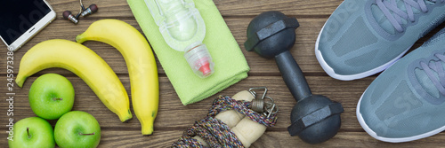Fotografía Top view of Healthy lifestyle concept, sport equipments and fresh foods on wood background