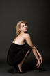 © LIGHTFIELD STUDIOS - attractive fashionable girl in black dress posing on black