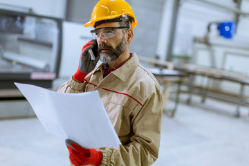 Engineer looking at plan in the factory