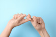 Woman showing word friend on color background, closeup. Sign language