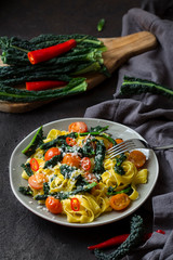 Canvas Print - Tagliatelle pasta with kale, tomatoes, pepper and parmesan cheese.