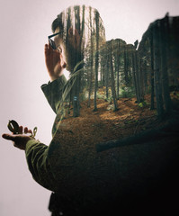 Double exposure with bearded traveler and dense forest. Metaphor of travel and camping.