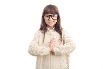 Wall Mural - Greeting in Asian! Portrait of a little girl of 7 years with glasses cupped her hands in front of her as a sign of Asian welcome, isolated on white background.